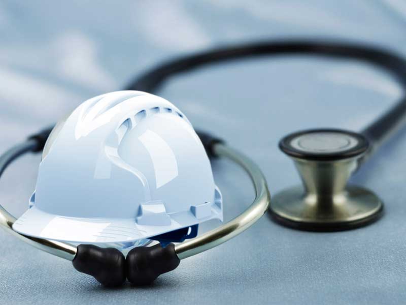 Casco de seguridad y estetoscopio, símbolos de seguridad industrial y salud ocupacional